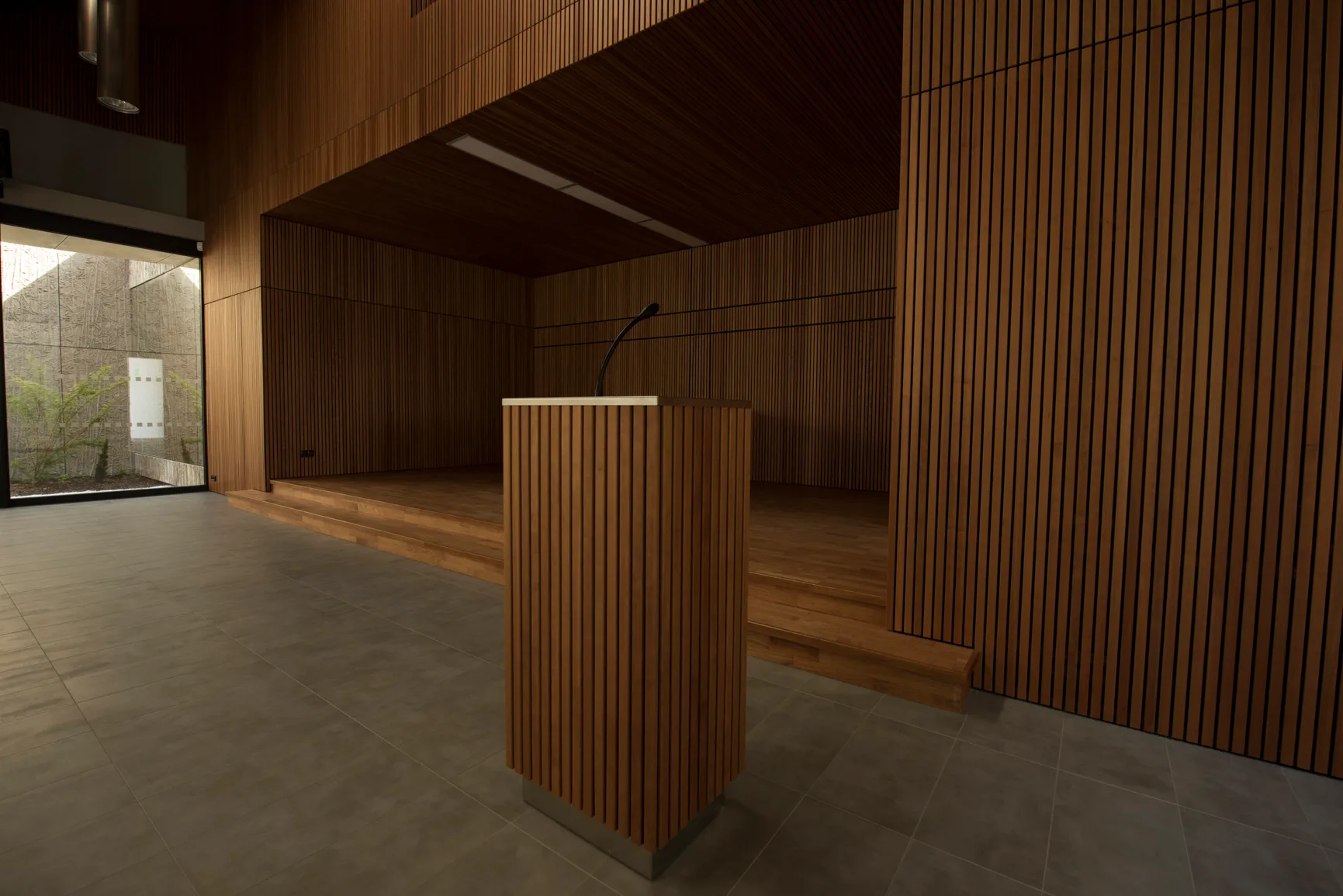 Dřevěný řečnický pult a obklad v architektonickém interiéru