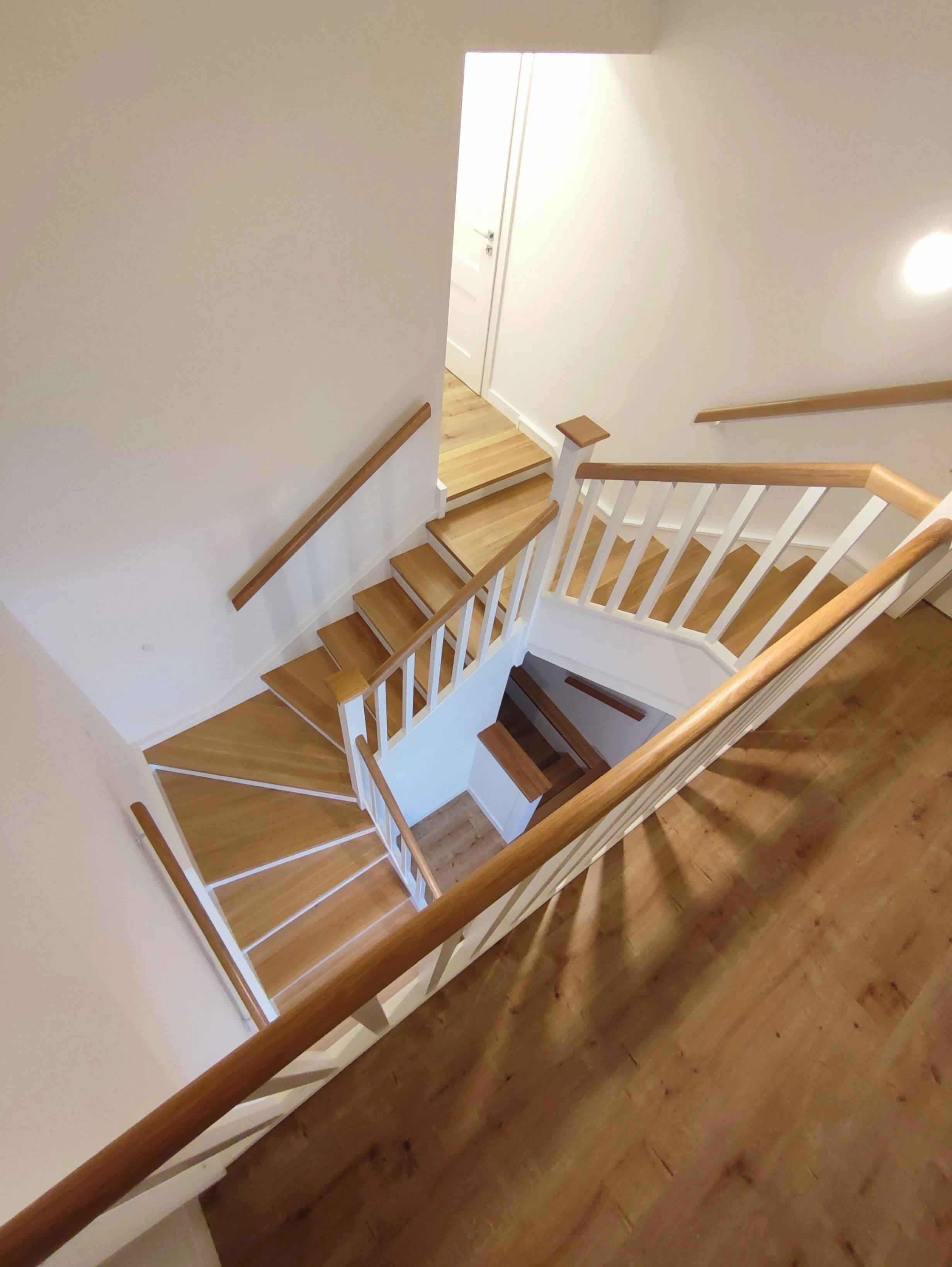 Dřevěný obklad víceramenného betonového schodiště