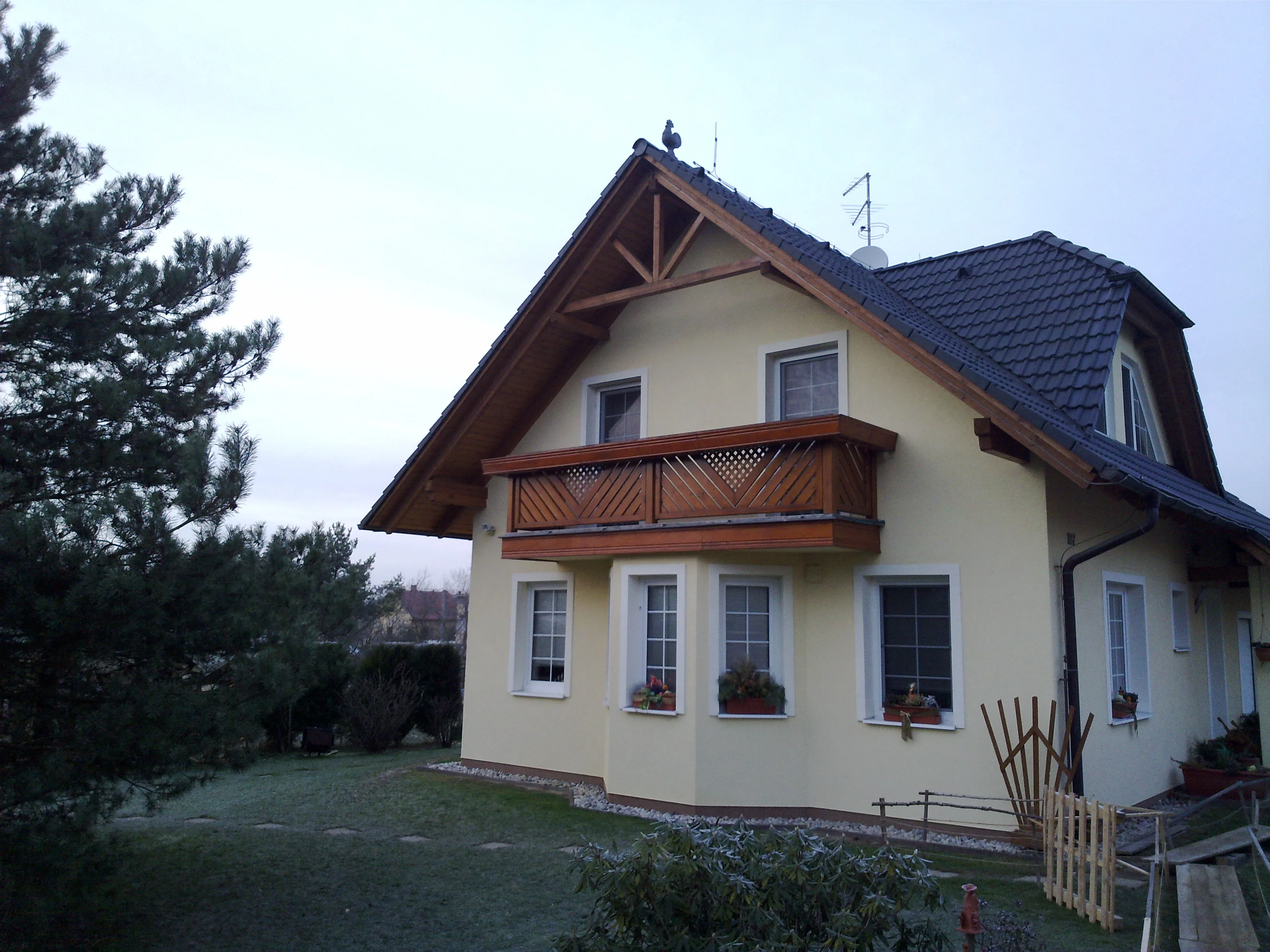 Rodinný dům s dřevěným balkonem a podhledem